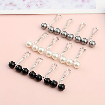 Set of pearl and black bead hair clips on a pink background